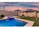 Beautiful backyard pool with raised spa, umbrella, and cabana with chairs and turf at 2052 E Scorpio Pl, Chandler, AZ 85249