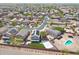 Expansive aerial view of a suburban neighborhood with a pool, green lawn, and solar panels at 21754 W Pima St, Buckeye, AZ 85326