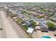 Expansive aerial view of a suburban neighborhood with a pool, green lawn, and solar panels at 21754 W Pima St, Buckeye, AZ 85326