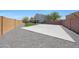 Spacious backyard featuring a concrete pad, gravel, artificial grass and block fence at 21754 W Pima St, Buckeye, AZ 85326