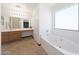 Bright and spacious bathroom with a large soaking tub and a vanity with a large mirror at 21754 W Pima St, Buckeye, AZ 85326