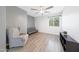 This bedroom has a large window, wood-look floors, and a stylish ceiling fan and lighting at 21754 W Pima St, Buckeye, AZ 85326