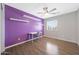 Bright bedroom features a vibrant accent wall, a ceiling fan, and a desk with shelves at 21754 W Pima St, Buckeye, AZ 85326