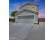 Two-story home with a large driveway and a two-car garage, taken during a colorful sunset at 21754 W Pima St, Buckeye, AZ 85326