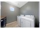 Efficient laundry room with modern, white washer and dryer, cabinets and neutral walls at 21754 W Pima St, Buckeye, AZ 85326