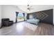 Stylish primary bedroom featuring a unique accent wall, wood-look floors, and bright window at 21754 W Pima St, Buckeye, AZ 85326