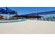 Scenic view of the Aquatic Center's lazy river, sun loungers, and playground area at Frontier Gathering Park at 21985 E Quintero Rd, Queen Creek, AZ 85142