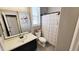 Well-lit bathroom featuring a single vanity, neutral color palette, and a shower with a decorative curtain at 21985 E Quintero Rd, Queen Creek, AZ 85142