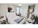 Comfortable bedroom featuring a cozy bed, modern decor, tiled floors, and natural lighting at 21985 E Quintero Rd, Queen Creek, AZ 85142