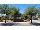 Attractive single-level home featuring a stone facade, desert landscaping, and mature trees at 21985 E Quintero Rd, Queen Creek, AZ 85142