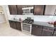 Close up view of a kitchen features stainless gas range and oven and dark cabinets at 21985 E Quintero Rd, Queen Creek, AZ 85142