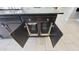 Kitchen island with built in double trash can and dark wood cabinets and countertops at 21985 E Quintero Rd, Queen Creek, AZ 85142