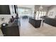 Open concept kitchen with island, stainless appliances, dark countertops and open access to pool and living areas at 21985 E Quintero Rd, Queen Creek, AZ 85142