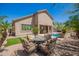 Inviting backyard patio with floral seating, a well-manicured lawn, and view of the pool for outdoor enjoyment at 22304 N 104Th Ln, Peoria, AZ 85383