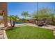 Lush backyard featuring a sparkling pool, grassy area, and comfortable seating arrangement perfect for outdoor gatherings at 22304 N 104Th Ln, Peoria, AZ 85383