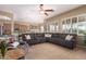 Spacious living room featuring plush seating, large windows, and a ceiling fan at 22304 N 104Th Ln, Peoria, AZ 85383