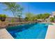 Beautiful pool with waterfall feature, complemented by lush landscaping, and outdoor seating area at 22304 N 104Th Ln, Peoria, AZ 85383