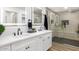 Modern bathroom featuring dual sinks, a spacious shower with black hardware and neutral tile at 2353 N 51St Pl, Phoenix, AZ 85008
