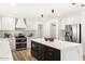 Bright kitchen featuring an island with a waterfall countertop, stainless steel appliances, and white cabinets at 2353 N 51St Pl, Phoenix, AZ 85008