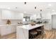Well-lit kitchen featuring white countertops and cabinetry, stainless appliances, and an island with bar stool seating at 2353 N 51St Pl, Phoenix, AZ 85008