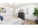 A bright main bedroom features wood-look tile, a modern ceiling light, and an inviting dresser at 2353 N 51St Pl, Phoenix, AZ 85008