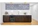 Modern wet bar features dark cabinets, quartz countertop, wine fridge, and stone backsplash with gold accents at 2353 N 51St Pl, Phoenix, AZ 85008