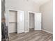 Bedroom showcasing two closets with white doors and modern wood-look flooring at 24350 S 208Th Pl, Queen Creek, AZ 85142