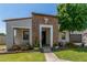 Charming home with a stone facade entrance, complemented by a well-kept lawn and blooming flowers at 24350 S 208Th Pl, Queen Creek, AZ 85142