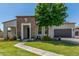 Charming single-story home featuring a stone facade, well-manicured lawn, and mature landscaping at 24350 S 208Th Pl, Queen Creek, AZ 85142