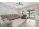 Bright living room featuring a gray sofa, ceiling fan, and sliding glass doors to the backyard at 24350 S 208Th Pl, Queen Creek, AZ 85142