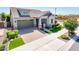 Beautiful single-Gathering home featuring stone accents, a well-manicured lawn, and a paver driveway and walkway at 2611 S Quaintance St, Gilbert, AZ 85295