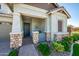 Inviting front porch showcasing stone accents on columns and a seating area, complemented by lush landscaping at 2611 S Quaintance St, Gilbert, AZ 85295