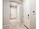 Bright hallway featuring neutral walls, archway, wood-look tile flooring, and a visible alarm system keypad at 2611 S Quaintance St, Gilbert, AZ 85295