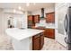 Open kitchen featuring white countertops, dark cabinets, stainless steel appliances, and wood-look tile flooring at 2611 S Quaintance St, Gilbert, AZ 85295