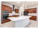 Modern kitchen featuring a large island, stainless steel appliances, and wood-look tile flooring at 2611 S Quaintance St, Gilbert, AZ 85295