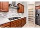 This kitchen features stainless steel appliances, a gas cooktop, granite countertops, and a stone tile backsplash at 2611 S Quaintance St, Gilbert, AZ 85295