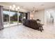 Open living room with tile flooring, sliding glass doors to the patio, and a ceiling fan at 2611 S Quaintance St, Gilbert, AZ 85295