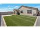 Manicured backyard boasts lush synthetic grass and a covered patio for relaxing at 28065 N 171St Dr, Surprise, AZ 85387