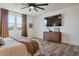Relaxing bedroom with a wooden dresser and large windows dressed with brown curtains at 28065 N 171St Dr, Surprise, AZ 85387