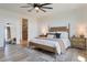 Tranquil bedroom featuring a wooden bed frame, soft lighting, and ensuite bathroom at 28065 N 171St Dr, Surprise, AZ 85387
