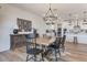 Charming dining room with a rustic wooden table, modern chandelier, and adjacent white kitchen at 28065 N 171St Dr, Surprise, AZ 85387
