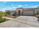 Exterior of single-story home with desert landscaping, stone accents, and a two-car garage at 28065 N 171St Dr, Surprise, AZ 85387