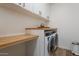 Bright laundry room features a counter and a modern washer and dryer at 28065 N 171St Dr, Surprise, AZ 85387