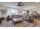 Spacious living room with large sectional sofa, decorative fan, and sliding glass doors at 28065 N 171St Dr, Surprise, AZ 85387