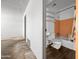 Bathroom with a toilet, sink, orange tile, shelving and a peek into the living area at 2834 E Michael Dr, Phoenix, AZ 85032