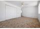 Spacious bedroom featuring carpet, a ceiling fan and a closet with white doors at 2834 E Michael Dr, Phoenix, AZ 85032