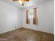 This is a small bedroom with dated floors, white walls, and a ceiling fan at 2834 E Michael Dr, Phoenix, AZ 85032