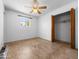 Bedroom showcasing a window, ceiling fan and closet with a wood door at 2834 E Michael Dr, Phoenix, AZ 85032