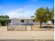 Charming single-story home featuring a white exterior, fenced yard, and mature shade tree at 2834 E Michael Dr, Phoenix, AZ 85032
