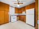 Traditional kitchen with wooden cabinets, white appliances, and a ceiling fan at 2834 E Michael Dr, Phoenix, AZ 85032